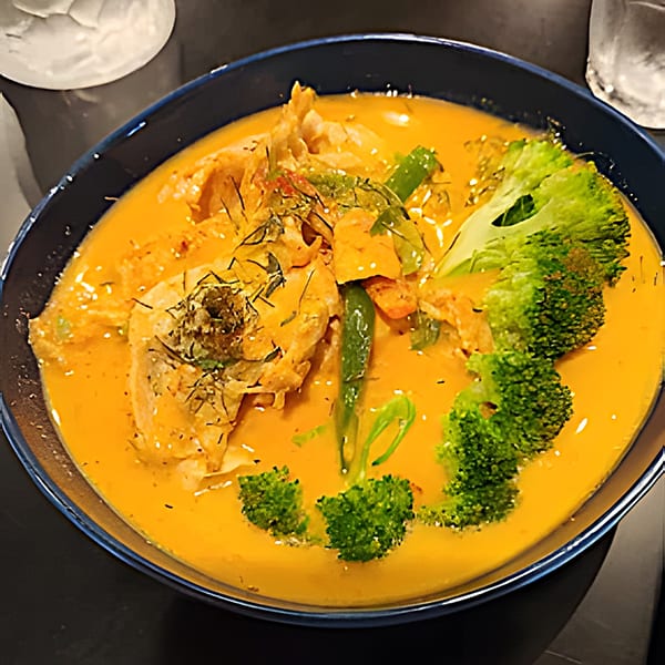 Clay Oven Restaurant's Indian curry with chicken, broccoli, and green beans in a rich orange sauce.